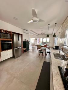 uma grande cozinha e sala de estar com electrodomésticos de aço inoxidável em NoMar no Guarujá