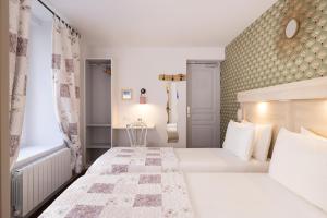 a bedroom with two beds and a window at Hôtel de Lion sur Mer in Lion-sur-Mer
