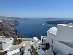 a view from the side of a white building with a lake at Zenith Blue Traditional Houses in Imerovigli