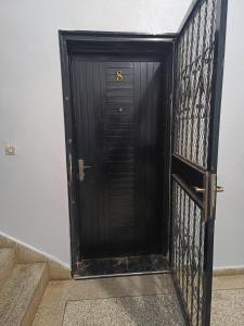 Una puerta negra con el número seis. en Appartement une chambre, en Meknès