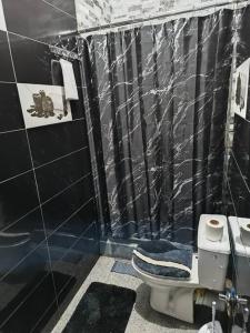 y baño en blanco y negro con aseo y ducha. en Appartement une chambre, en Meknès