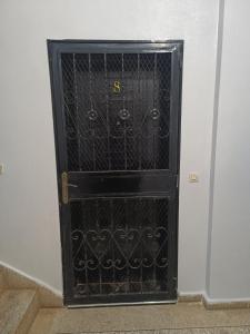 una puerta negra con una puerta metálica en una habitación en Appartement une chambre, en Meknès