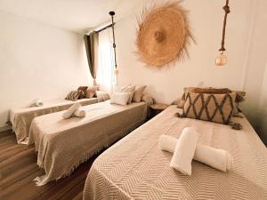 een kamer met 2 bedden en een bank. bij Chakra House Fuerteventura in Corralejo