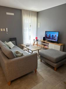 - un salon avec un canapé et une télévision dans l'établissement Juanita Home (Duplex de dos domitorios en complejo con pileta), à La Plata