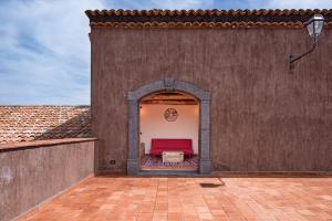 patio z czerwoną kanapą w ścianie w obiekcie Etna Quota Mille w mieście Randazzo