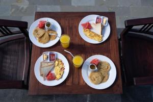 uma mesa de madeira com pratos de comida para o pequeno-almoço em Pini Sentana Village em Nusa Penida