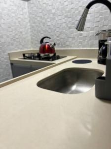 a kitchen sink with a tea kettle on a stove at Apartamento Copacabana in Rio de Janeiro