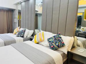 ein Hotelzimmer mit 2 Betten und Kissen in der Unterkunft Cozy Family Nook at Makati in Manila