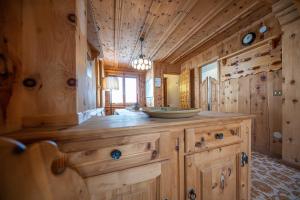 W pokoju znajduje się duża drewniana łazienka z umywalką. w obiekcie Apartments & Rooms MyHolidayLivigno w Livigno +37 zdjęć