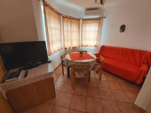 sala de estar con sofá rojo y mesa en Apartma Brešan, en Kobarid
