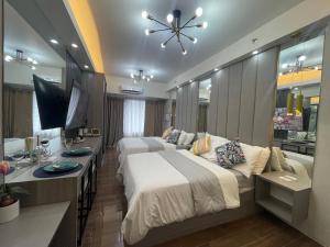 ein Hotelzimmer mit 2 Betten und einem TV in der Unterkunft Cozy Family Nook at Makati in Manila