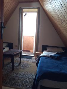 a bedroom with a bed and a window with a door at Kopaniktreskapotok15eu in Kopaonik