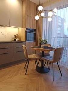 uma sala de jantar com uma mesa e cadeiras numa cozinha em Apartments with a balcony and an impressive terrace on the roof of the house em Vilnius