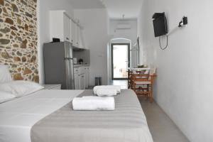 a white room with a bed with towels on it at Chora Cozy Studios in Kithnos