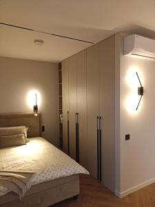 a bedroom with a bed and a white cabinet at Apartments with a balcony and an impressive terrace on the roof of the house - PRIVATE FREE CAR PARKING in Vilnius +16 photos