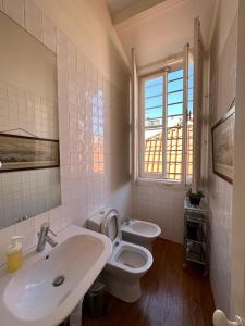 La salle de bains est pourvue d'un lavabo, de toilettes et d'une fenêtre. dans l'établissement Apartamento no Centro de Lisboa, à Lisbonne