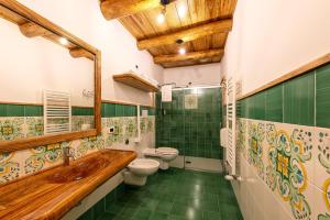 Etna Quota Mille في رانداتسو: حمام مع دورتين مياه وحوض استحمام خشبي