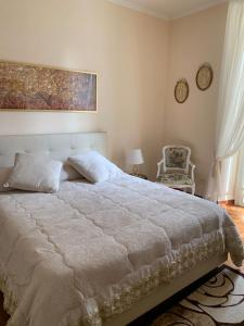 a bedroom with a large white bed and a chair at Sotto le stelle di Capua in Capua