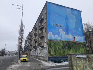 um edifício com um grande mural ao lado em Podolski Hostel em Kiev