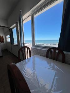 a table and chairs with a view of the ocean at La PerlaApart in Mar del Plata