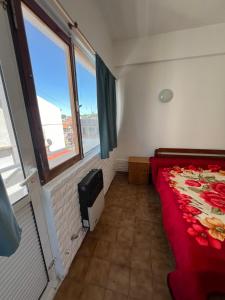 a small bedroom with a bed and a window at La PerlaApart in Mar del Plata