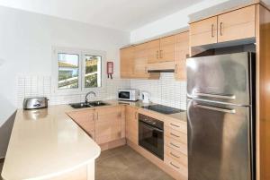 埃斯梅爾卡達爾的住宿－Villa Arual，厨房配有木制橱柜和不锈钢冰箱。