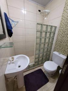 een badkamer met een witte wastafel en een toilet bij Casa Griojo a beira mar in Cidreira
