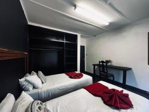 um quarto com 2 camas com toalhas vermelhas em Phalaborwa Apartments em Phalaborwa