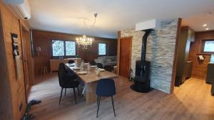 a living room with a dining table and a fireplace at Chalet Le Dahu in La Bresse