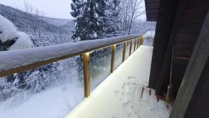 a snow covered railing on a balcony of a house at Chalet Le Dahu in La Bresse
