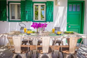 ステリダにあるMontana Villaの緑のドア、テーブル、椅子が備わるダイニングルーム