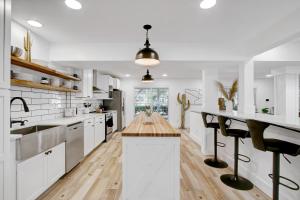 a kitchen with white cabinets and a wooden counter top at Cactus Club - A Birdy Vacation Rental in San Antonio