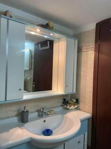 uma casa de banho com um lavatório e um espelho em Honeybee Apartment em Tessalônica