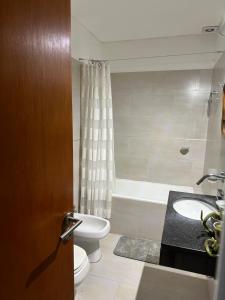 een badkamer met een toilet, een wastafel en een bad bij Juanita Home (Duplex de dos domitorios en complejo con pileta) in La Plata