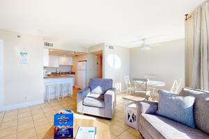 a living room with a couch and chairs and a table at Sunbird #408E in Panama City Beach