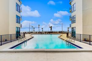 a swimming pool in the middle of two buildings at Sunbird #408E in Panama City Beach