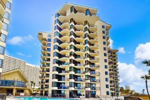 a tall building with a pool in front of it at Sunbird #408E in Panama City Beach