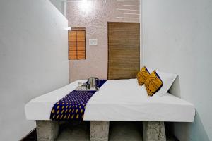 SPOT ON Friends Service Appartment في ناغبور: غرفة صغيرة مع سرير ومغسلة