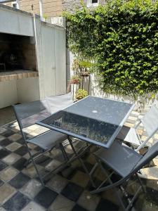 een glazen tafel en 2 stoelen op een patio bij Juanita Home (Duplex de dos domitorios en complejo con pileta) in La Plata