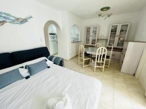 1 dormitorio con 1 cama blanca, mesa y sillas en A756 - Calasol - 2004 Finestrat s.l., en Cala de Finestrat