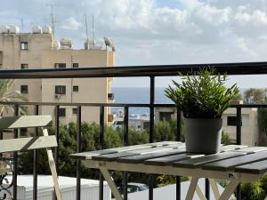 a patio table with a potted plant on a balcony at Coastal Elegance Maisonette in Limassol