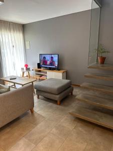 un soggiorno con divano e TV di Juanita Home (Duplex de dos domitorios en complejo con pileta) a La Plata
