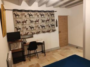 a room with a curtain on a wall with a table and a desk at Chambres d'hôtes des Cigognes in Marlieux