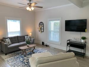 a living room with a couch and a flat screen tv at King Suite- Walk to UNC/Franklin St, Near Hospital in Chapel Hill