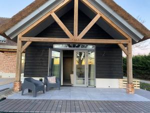 einen Pavillon mit einer Glastür und einem Stuhl auf einer Terrasse in der Unterkunft De Slaapsoof in Lier