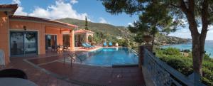 a house with a swimming pool next to the ocean at Traditional stone house by the sea. in Petriaí