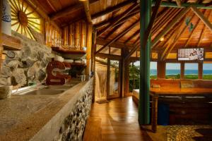 a kitchen with a sink and a stone wall at Cabañas Cochapunko I Espectacular vista 360 in Ayampe