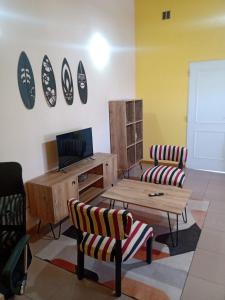 a living room with two chairs and a table at Mi Casa Tu Casa in Lago Puelo