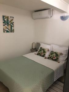 una camera da letto con un letto con lenzuola e cuscini verdi di Chez Laurenn a Le Carbet