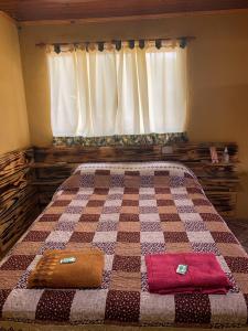 1 cama con 2 almohadas frente a una ventana en hospedaje don mario en San Ignacio